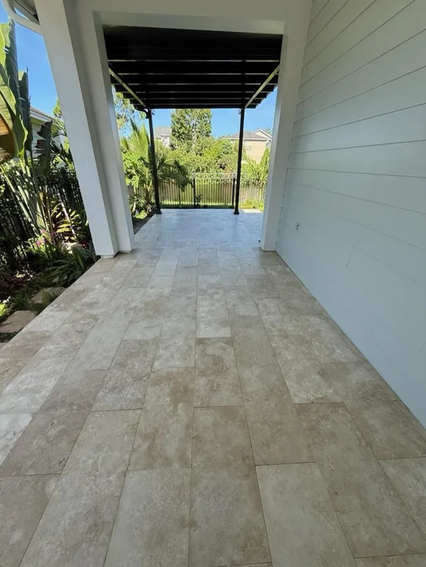 Travertine-look pavers under a covered patio